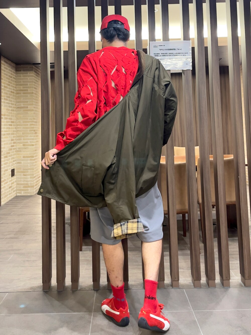レッド系のニット/セーター、レッド系のスニーカー、グリーン系のブルゾンを着用したメンズの秋コーディネートの3枚目の写真
