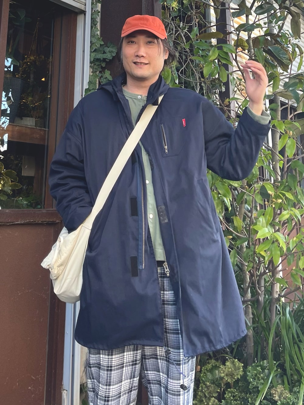 グリーン系のカーディガン/ボレロ、ブルー系のモッズコート、ホワイト系のショルダーバッグを着用したメンズの春コーディネートの3枚目の写真