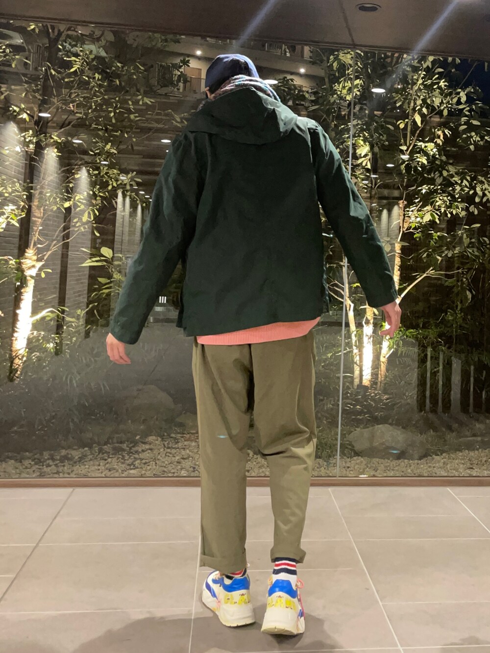 ピンク系のニット/セーター、グリーン系のマウンテンパーカー、グリーン系のその他パンツを着用したメンズの春コーディネートの5枚目の写真