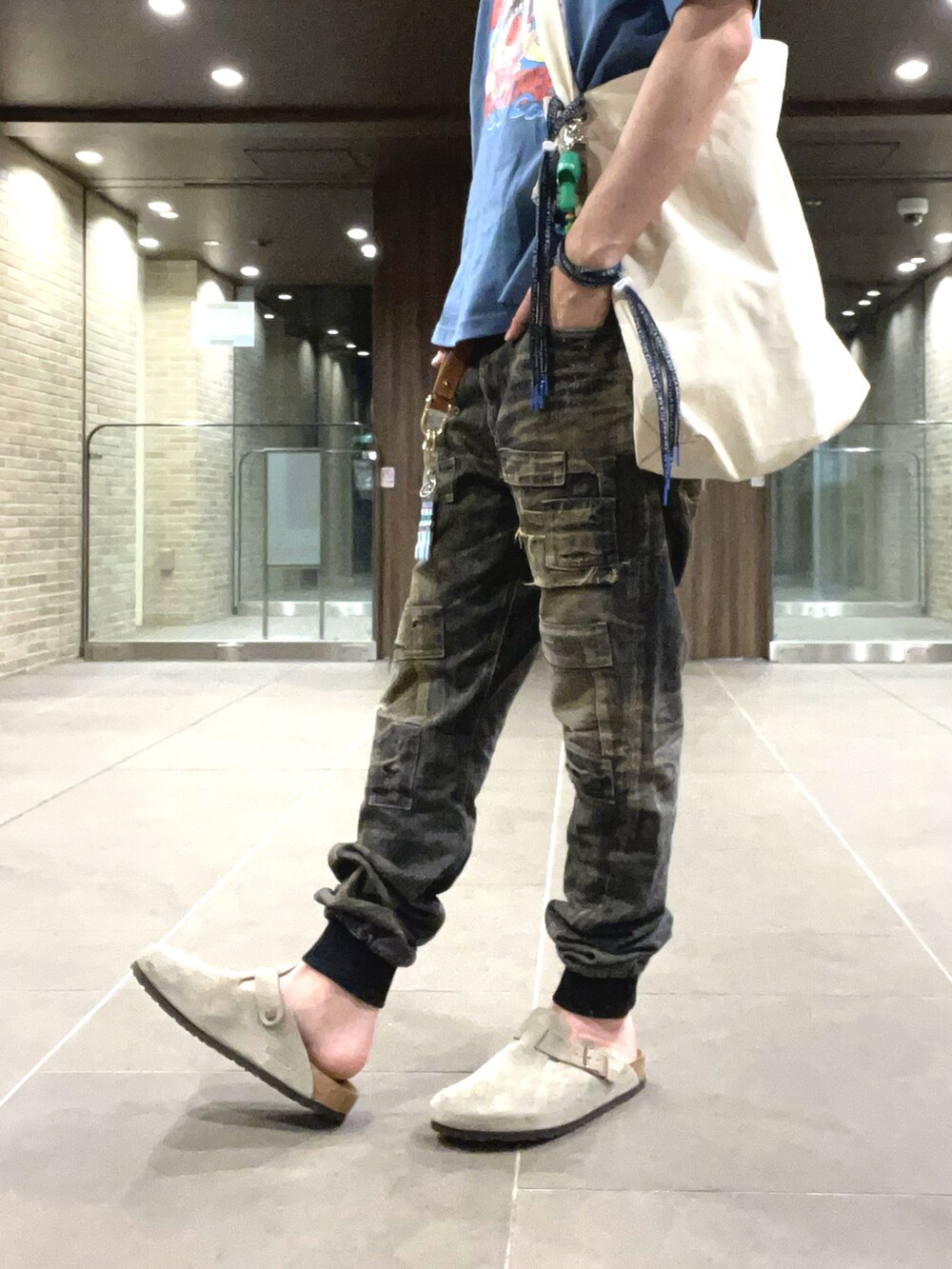 ブルー系のTシャツ/カットソー、ブラック系のデニムパンツ、ベージュ系のサンダルを着用したメンズの夏コーディネートの4枚目の写真