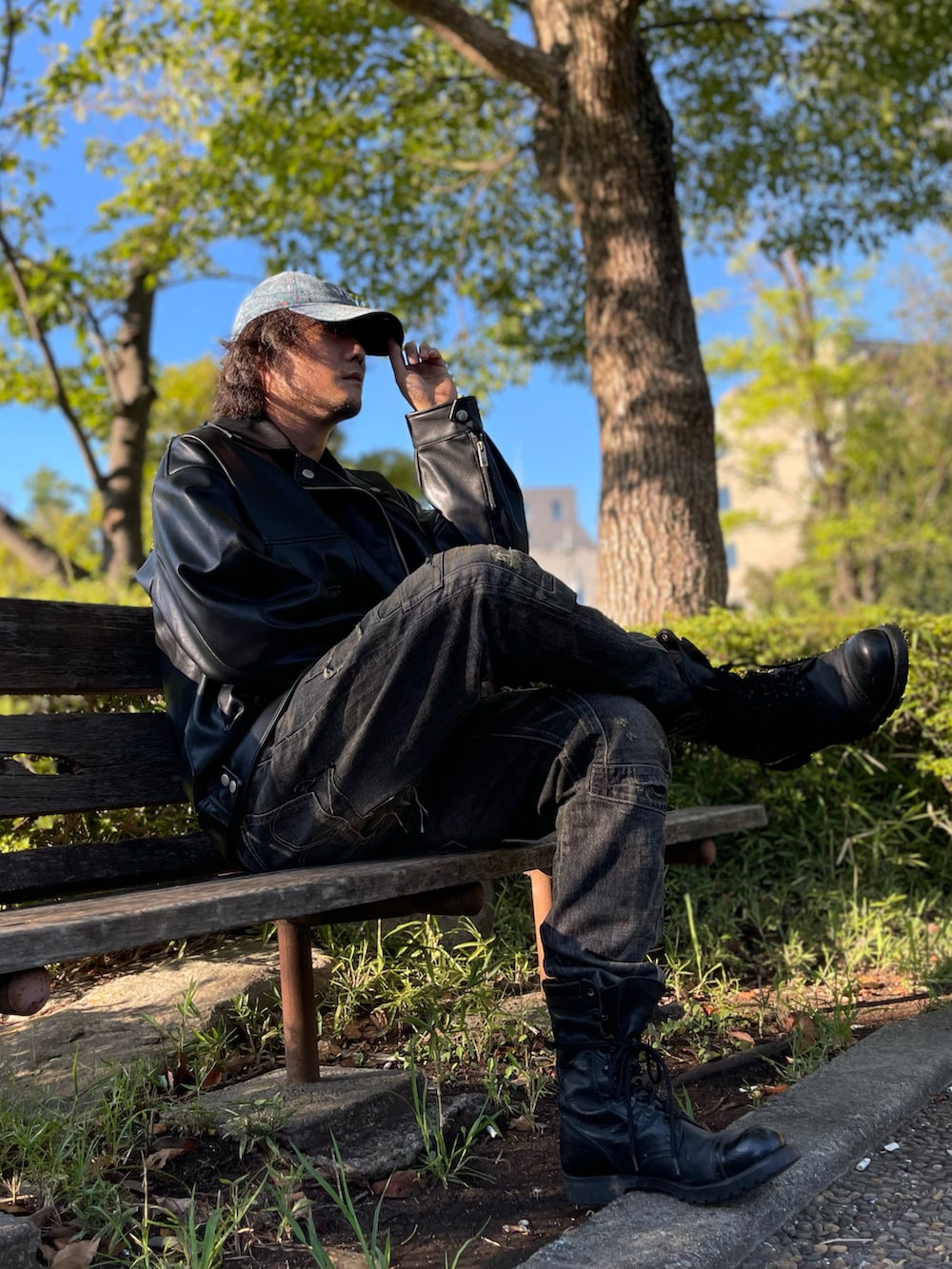 ブルー系のTシャツ/カットソー、ブラック系のライダースジャケット、ブラック系のデニムパンツを着用したメンズの秋コーディネートの4枚目の写真