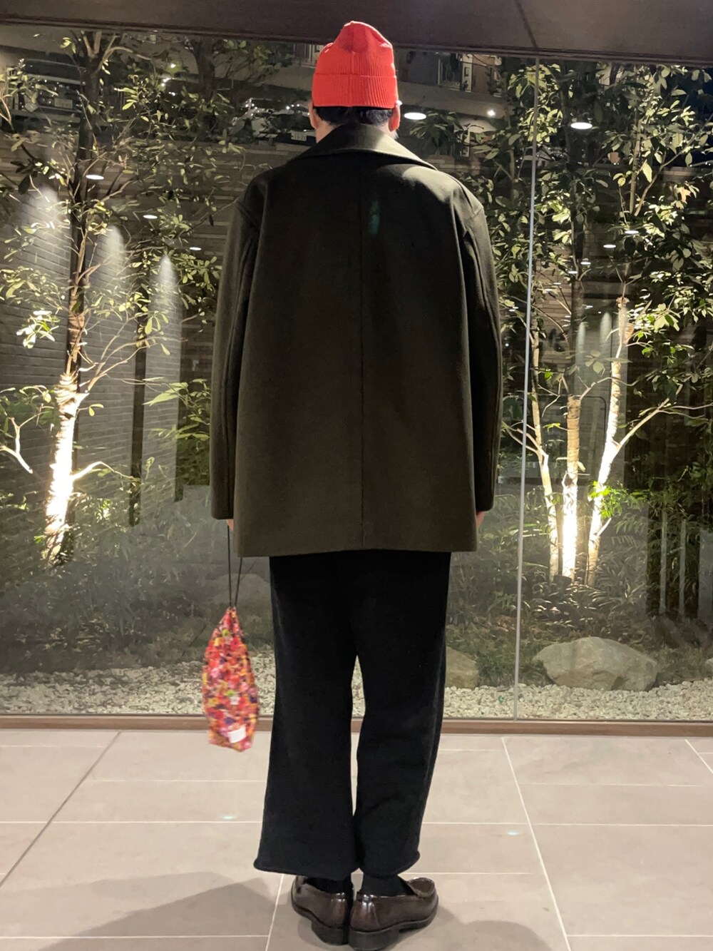 グリーン系のピーコート、ブラック系のニット/セーター、ブラック系のその他パンツを着用したメンズの冬コーディネートの3枚目の写真