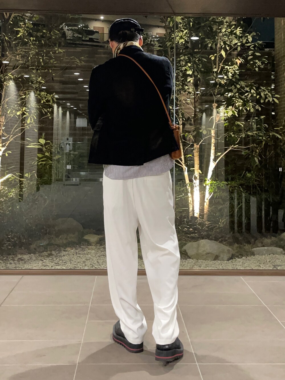 グレー系のシャツ/ブラウス、ブラック系のテーラードジャケット、ブラウン系のショルダーバッグを着用したメンズの春コーディネートの3枚目の写真