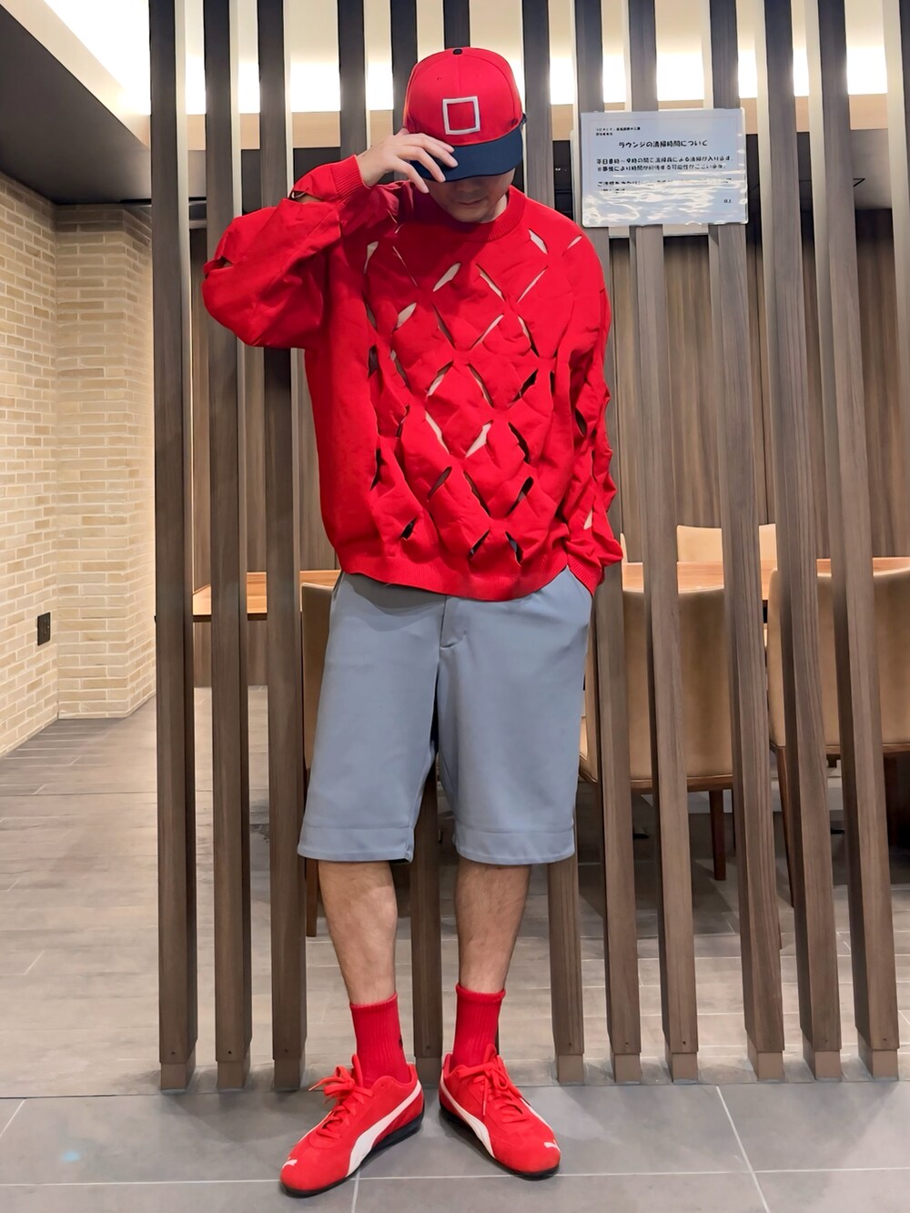 レッド系のニット/セーター、レッド系のスニーカー、グリーン系のブルゾンを着用したメンズの秋コーディネートの2枚目の写真