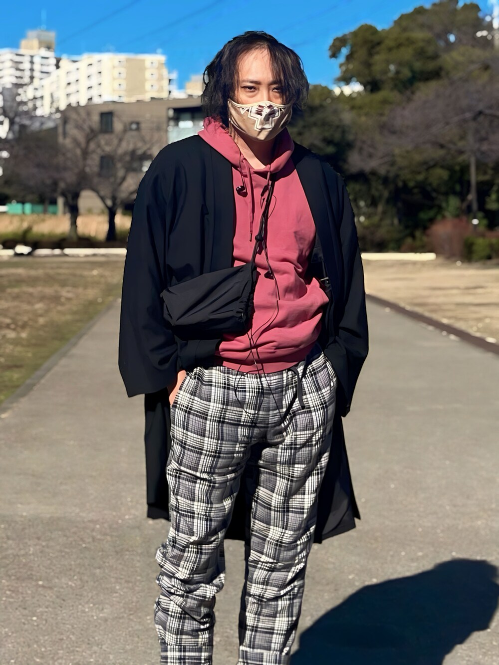 ブラック系のノーカラージャケット、ピンク系のパーカー、グレー系のパンツを着用したメンズの冬コーディネートの2枚目の写真