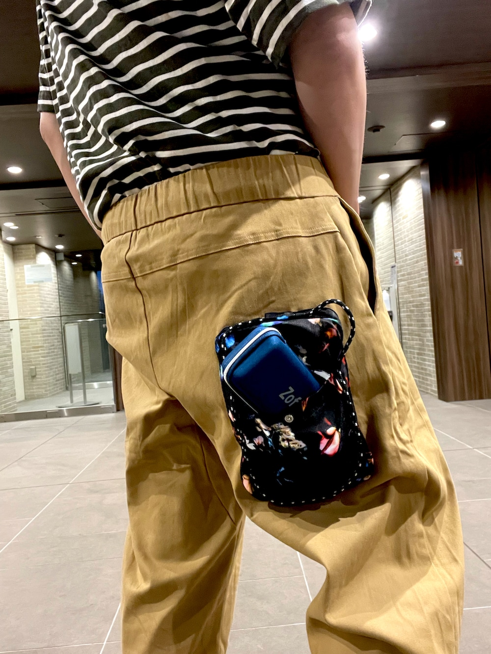 グリーン系のTシャツ/カットソー、ベージュ系のチノパンツ、ベージュ系のサンダルを着用したメンズの夏コーディネートの5枚目の写真