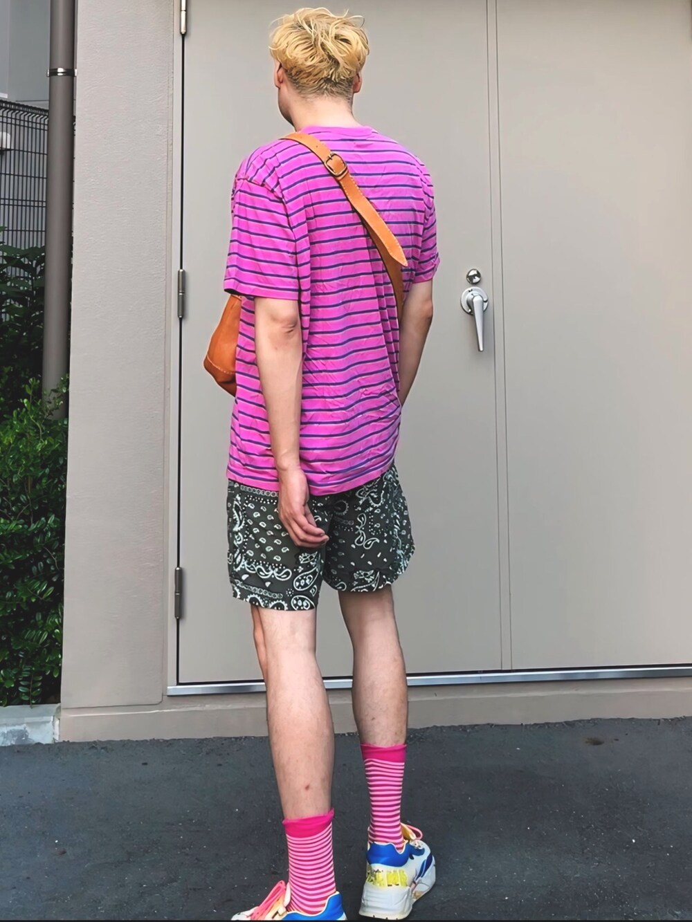ピンク系のTシャツ/カットソー、ブラウン系のショルダーバッグ、グリーン系のパンツを着用したメンズの夏コーディネートの4枚目の写真