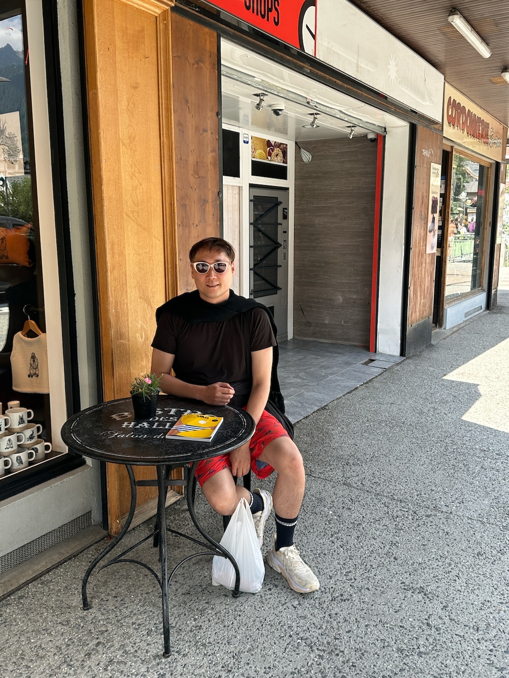 ベージュ系のスニーカー、レッド系のパンツ、ベージュ系のサングラスを着用したメンズの夏コーディネートの2枚目の写真