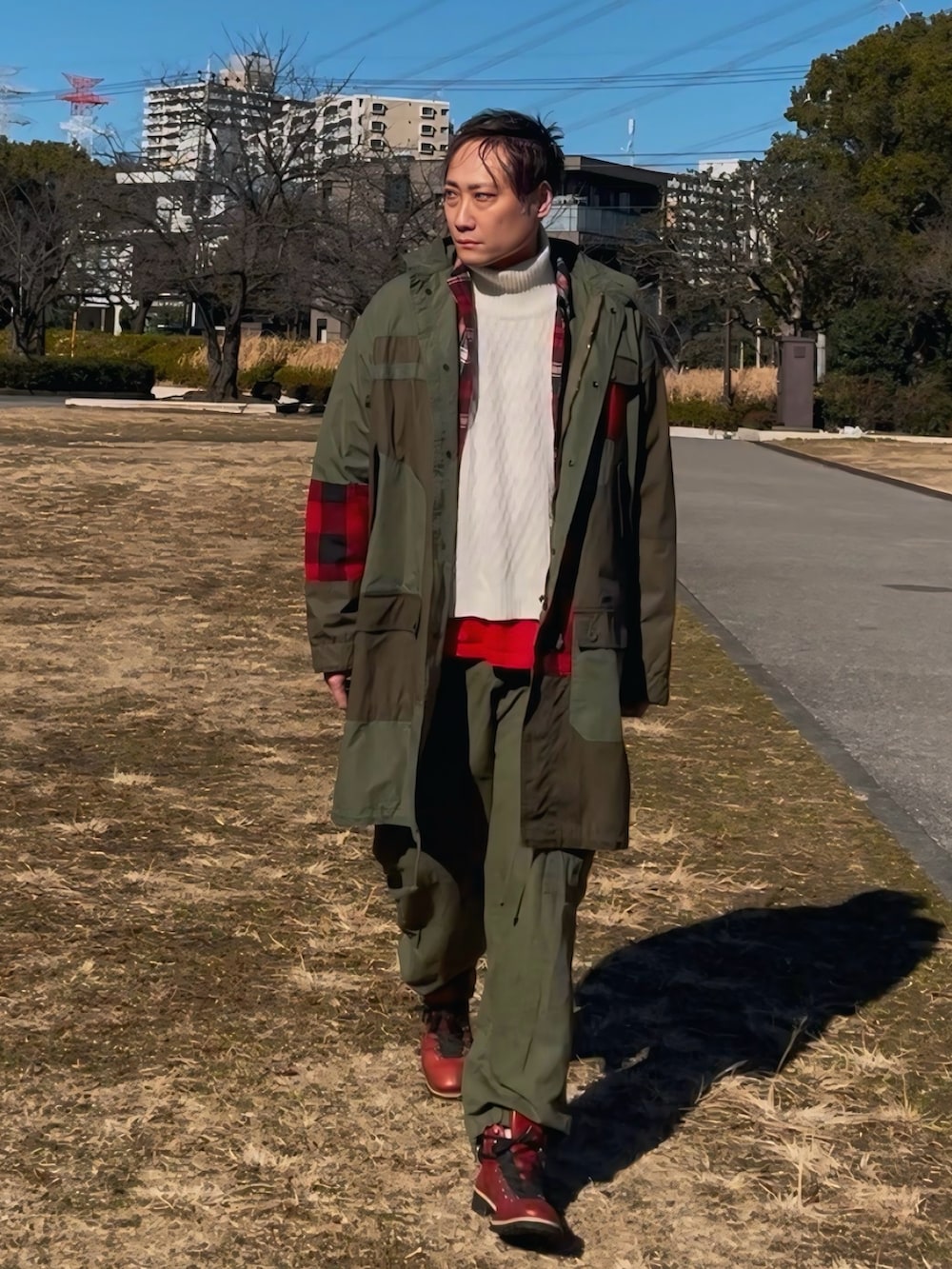 グリーン系のモッズコート、グリーン系のカーゴパンツ、レッド系のブーツを着用したメンズの冬コーディネートの3枚目の写真