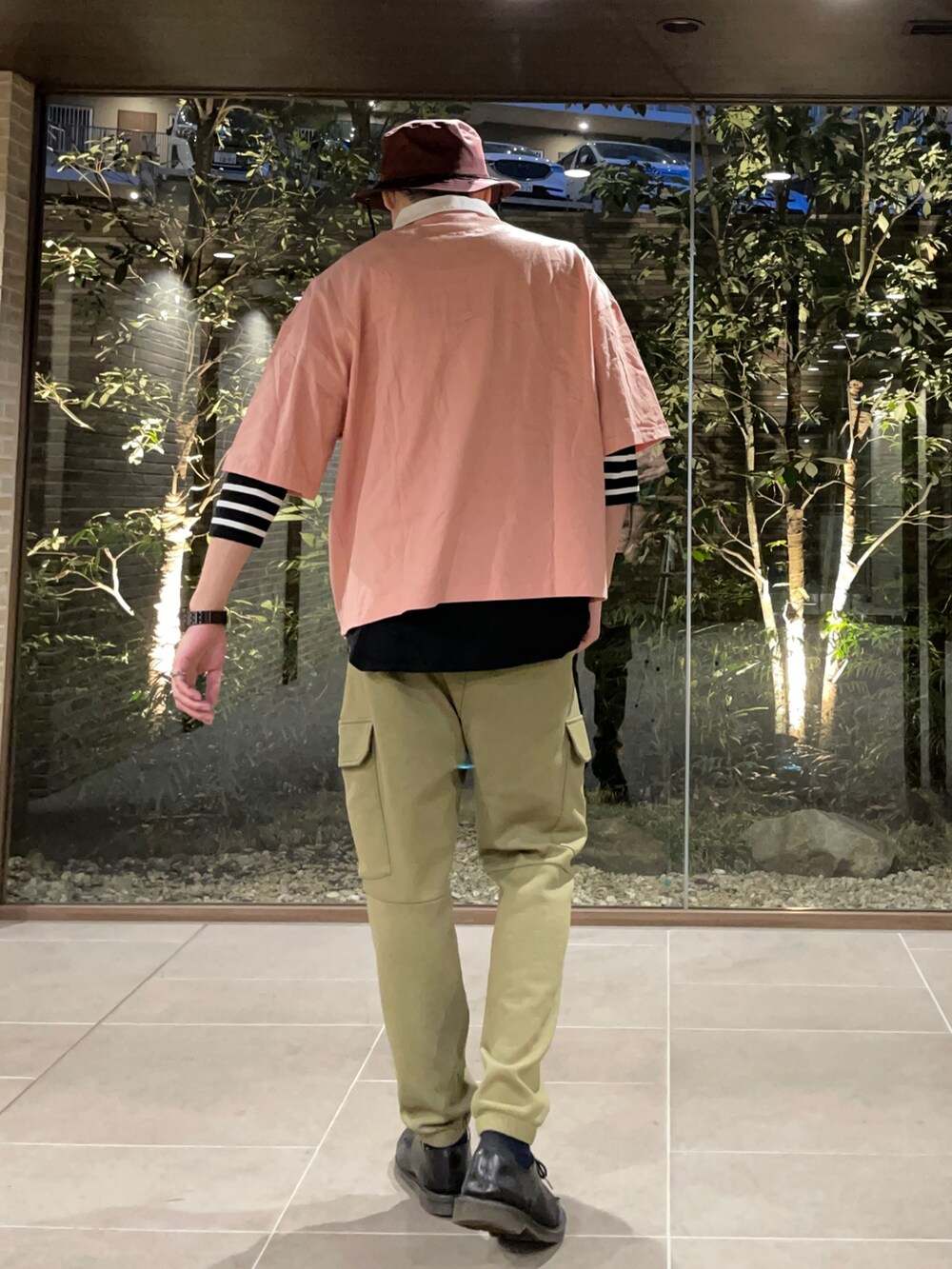 ピンク系のTシャツ/カットソー、ブラック系のTシャツ/カットソー、グリーン系のカーゴパンツを着用したメンズの春コーディネートの3枚目の写真