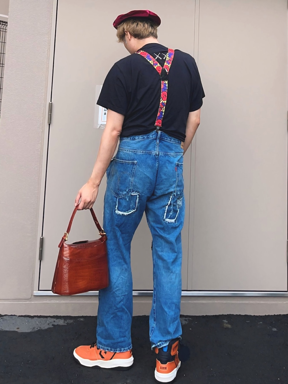 ブラック系のTシャツ/カットソー、ブルー系のデニムパンツ、オレンジ系のスニーカーを着用したメンズの秋コーディネートの2枚目の写真