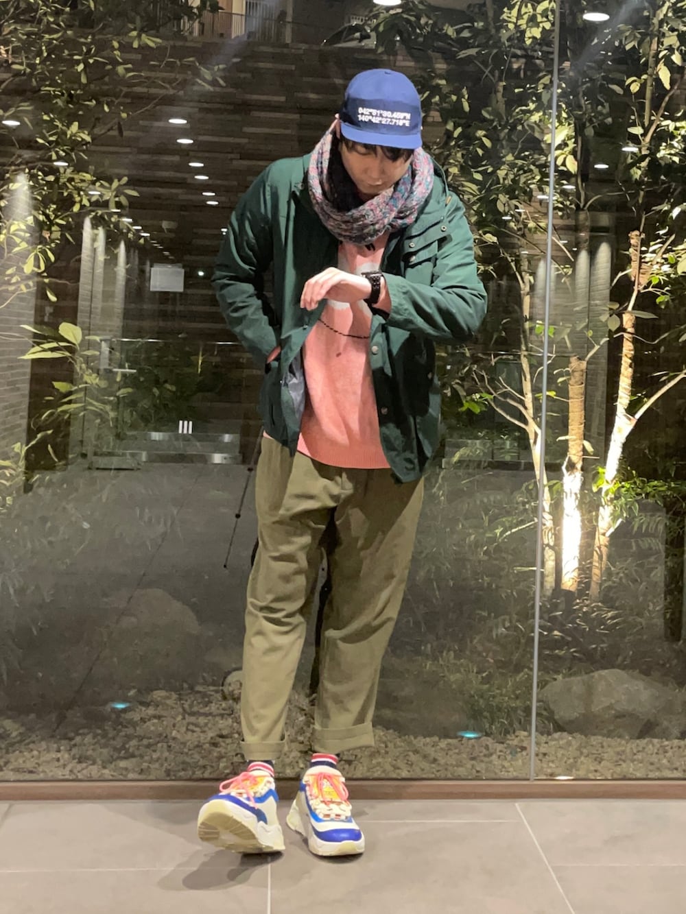 ピンク系のニット/セーター、グリーン系のマウンテンパーカー、グリーン系のその他パンツを着用したメンズの春コーディネートの2枚目の写真