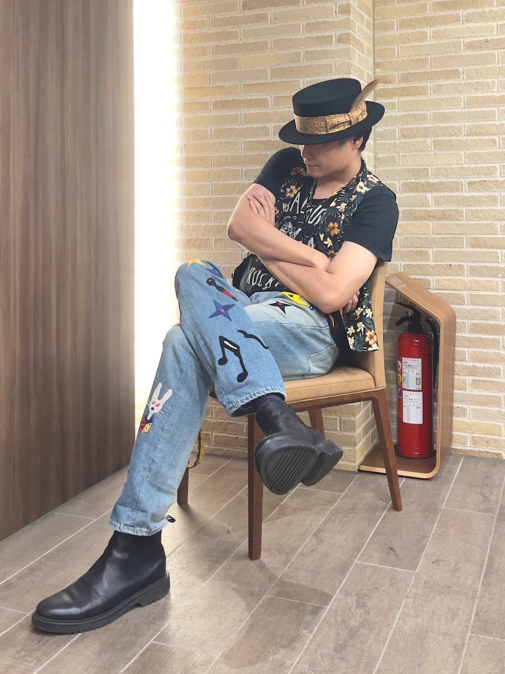 ブルー系のデニムパンツ、ブラック系のTシャツ/カットソー、グリーン系のベストを着用したメンズの秋コーディネートの4枚目の写真