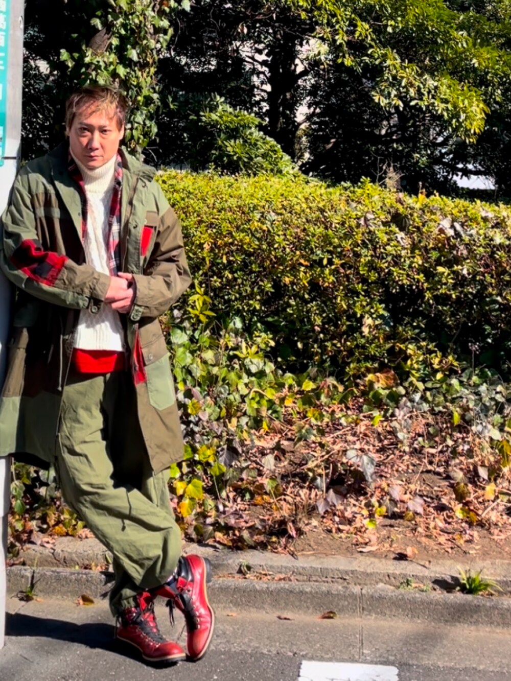 グリーン系のモッズコート、グリーン系のカーゴパンツ、レッド系のブーツを着用したメンズの冬コーディネートの2枚目の写真