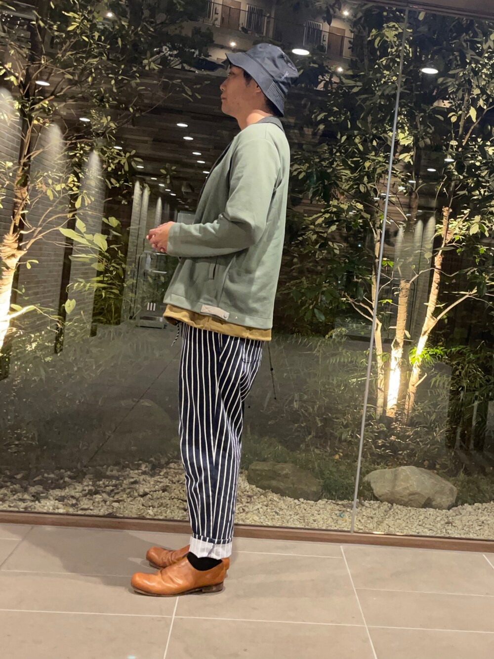 ホワイト系のTシャツ/カットソー、グリーン系のカーディガン/ボレロ、ブルー系のその他パンツを着用したメンズの秋コーディネートの2枚目の写真