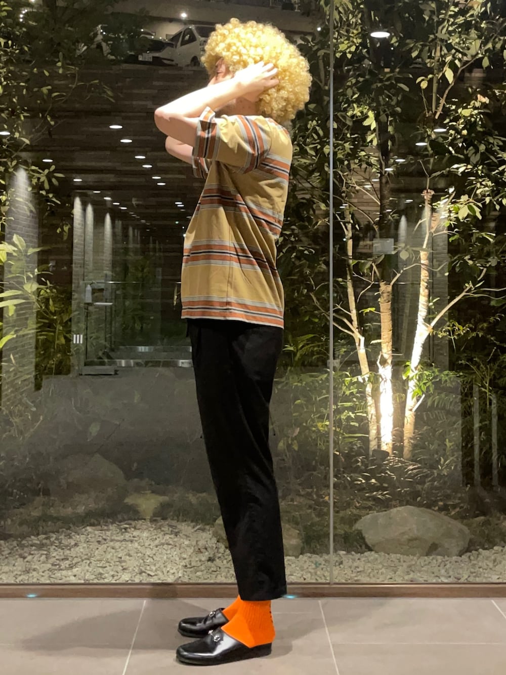 ブラウン系のTシャツ/カットソー、ブラック系のスラックス、ブラック系のサンダルを着用したメンズの春コーディネートの2枚目の写真