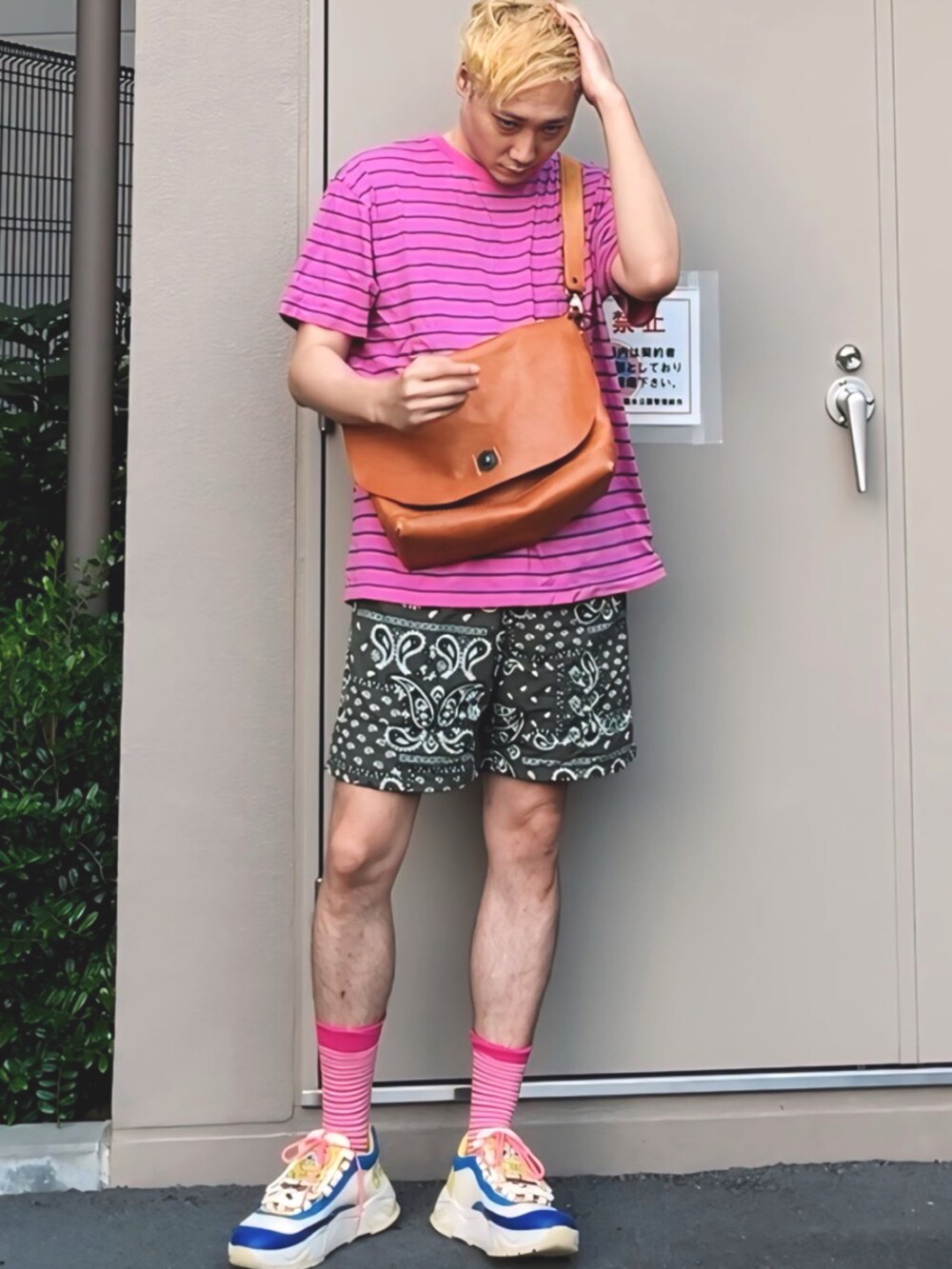 ピンク系のTシャツ/カットソー、ブラウン系のショルダーバッグ、グリーン系のパンツを着用したメンズの夏コーディネートの3枚目の写真