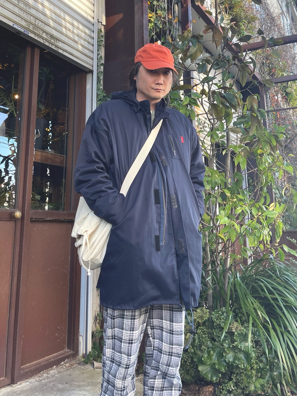 グリーン系のカーディガン/ボレロ、ブルー系のモッズコート、ホワイト系のショルダーバッグを着用したメンズの春コーディネートの4枚目の写真