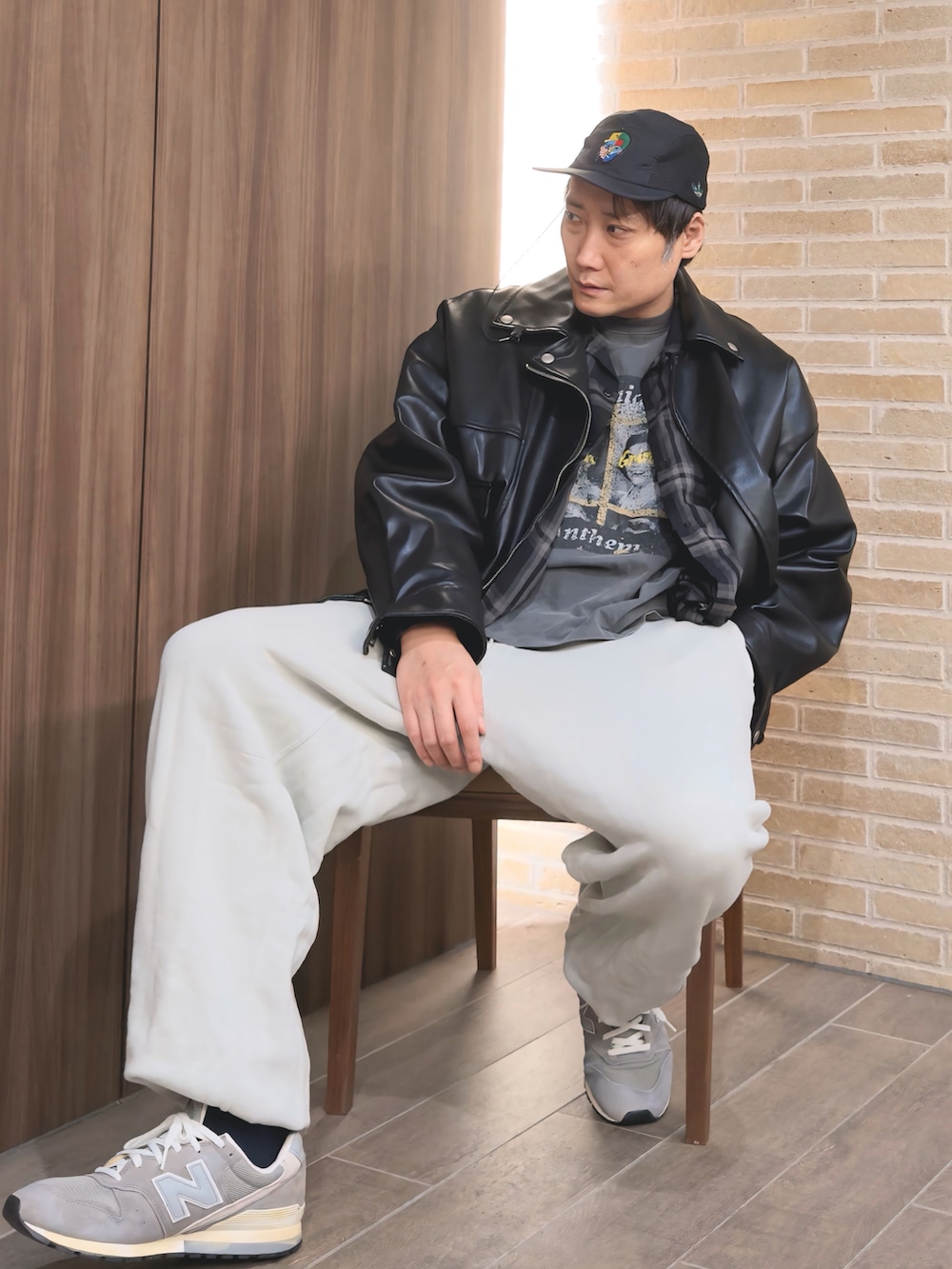 ブラック系のライダースジャケット、ブラック系のTシャツ/カットソー、ホワイト系のスウェットパンツを着用したメンズの秋コーディネートの4枚目の写真