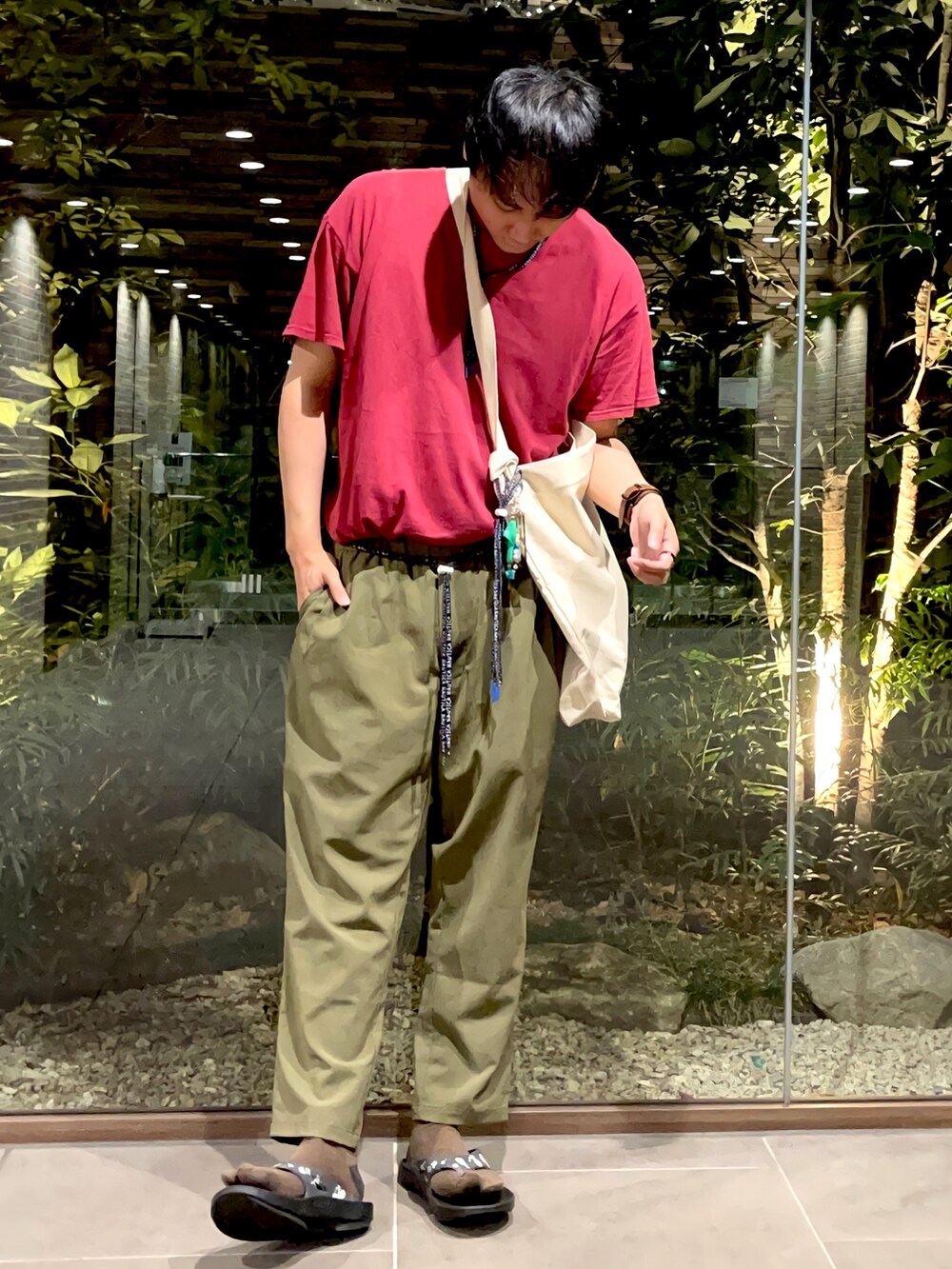 ベージュ系のショルダーバッグ、グリーン系のその他パンツ、ブラック系のサンダルを着用したメンズの夏コーディネートの2枚目の写真