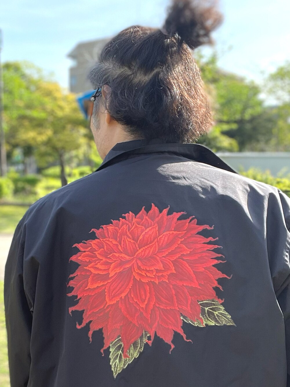ブラック系のナイロンジャケット、ブルー系のTシャツ/カットソー、ブルー系のデニムパンツを着用したメンズの春コーディネートの5枚目の写真