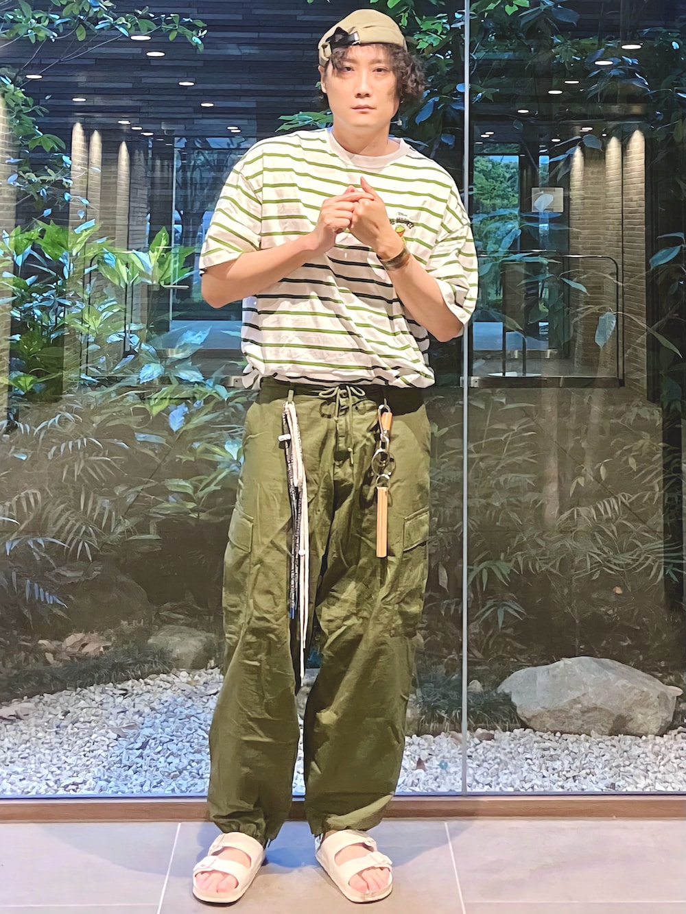 グリーン系のTシャツ/カットソー、ホワイト系のシューズアクセサリー、ブルー系のシューズアクセサリーを着用したメンズの夏コーディネートの2枚目の写真