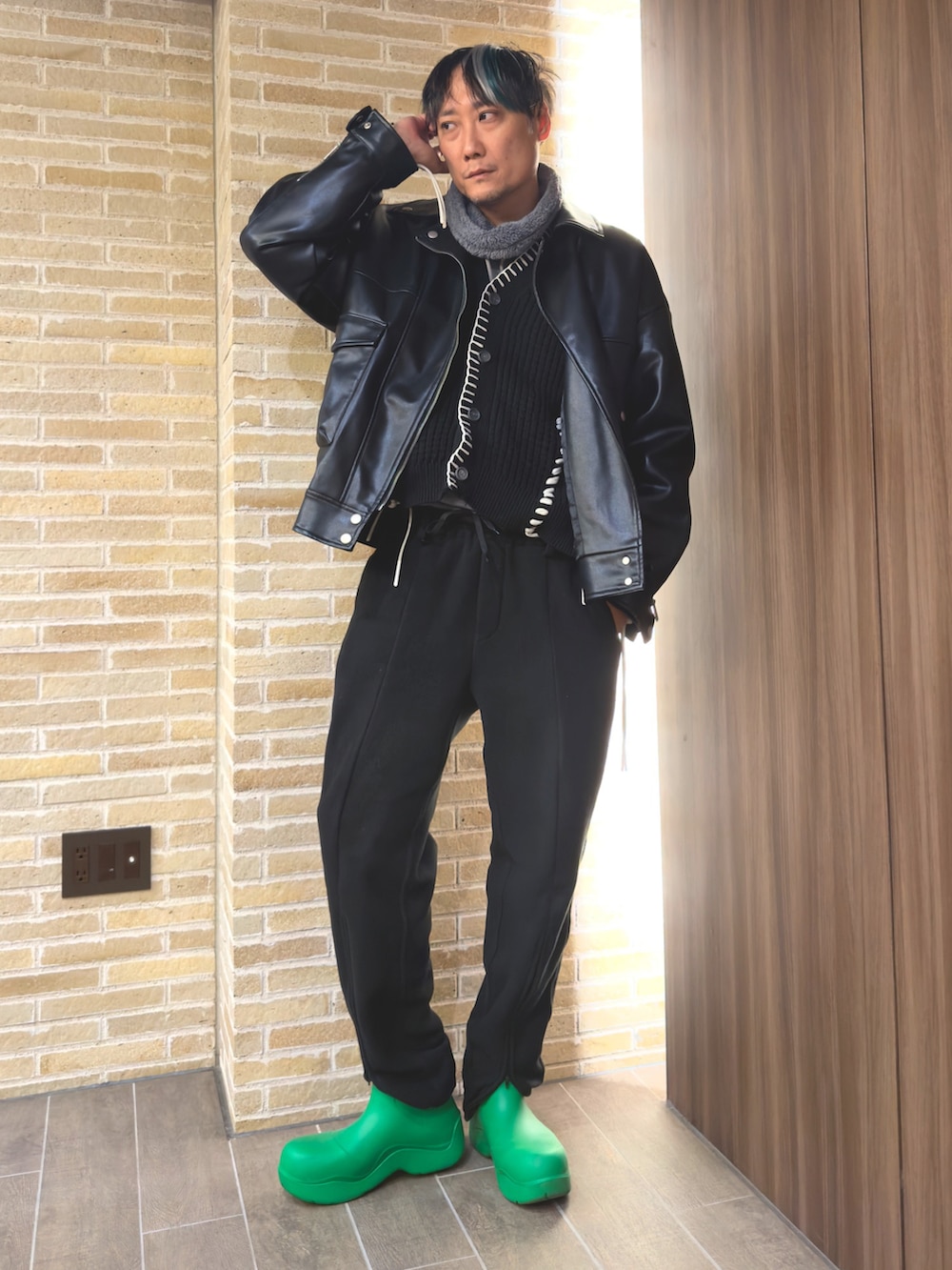 ブラック系のライダースジャケット、グレー系のパーカー、ブラック系のカーディガン/ボレロを着用したメンズの冬コーディネートの2枚目の写真