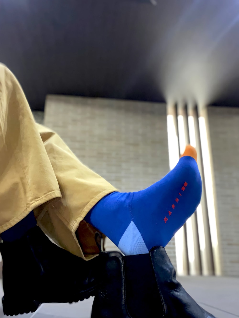 グレー系のTシャツ/カットソー、オレンジ系のニット/セーター、イエロー系のパンツを着用したメンズの冬コーディネートの4枚目の写真