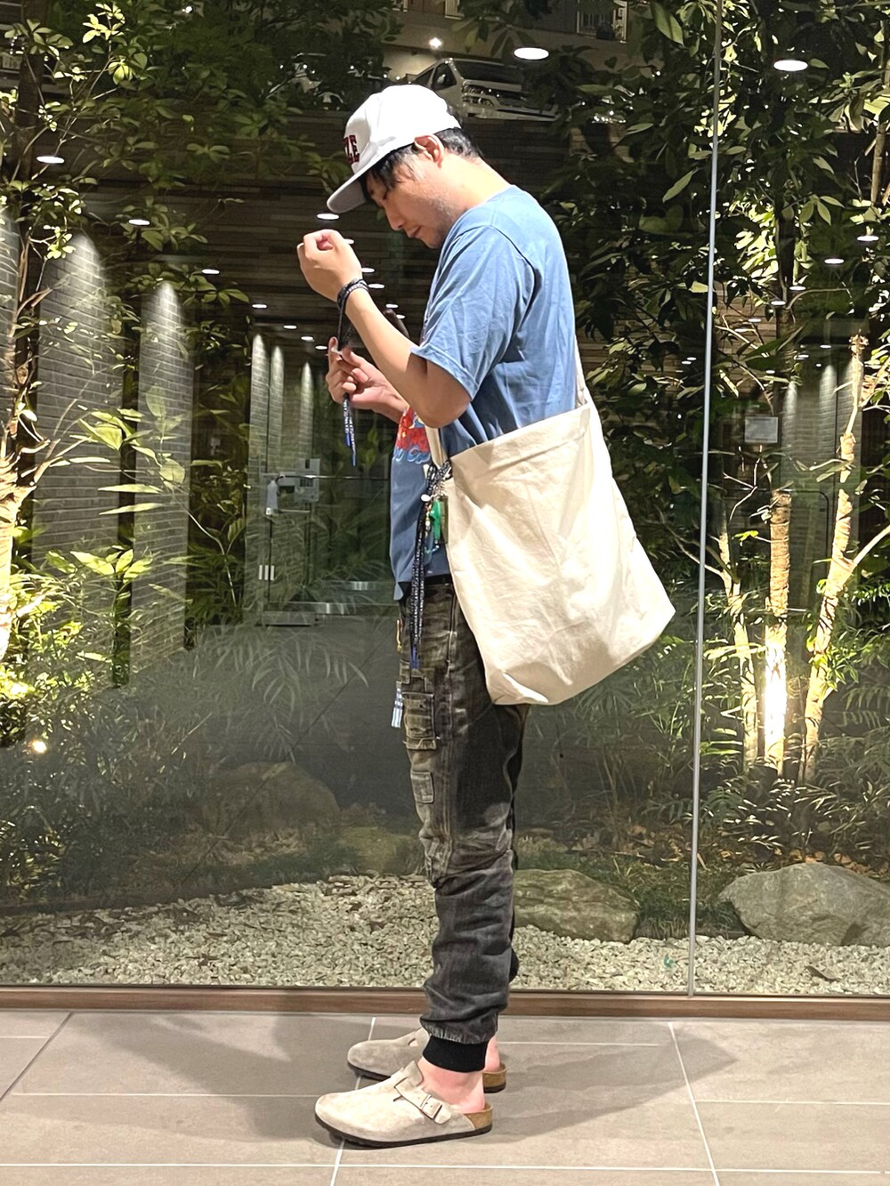 ブルー系のTシャツ/カットソー、ブラック系のデニムパンツ、ベージュ系のサンダルを着用したメンズの夏コーディネートの2枚目の写真