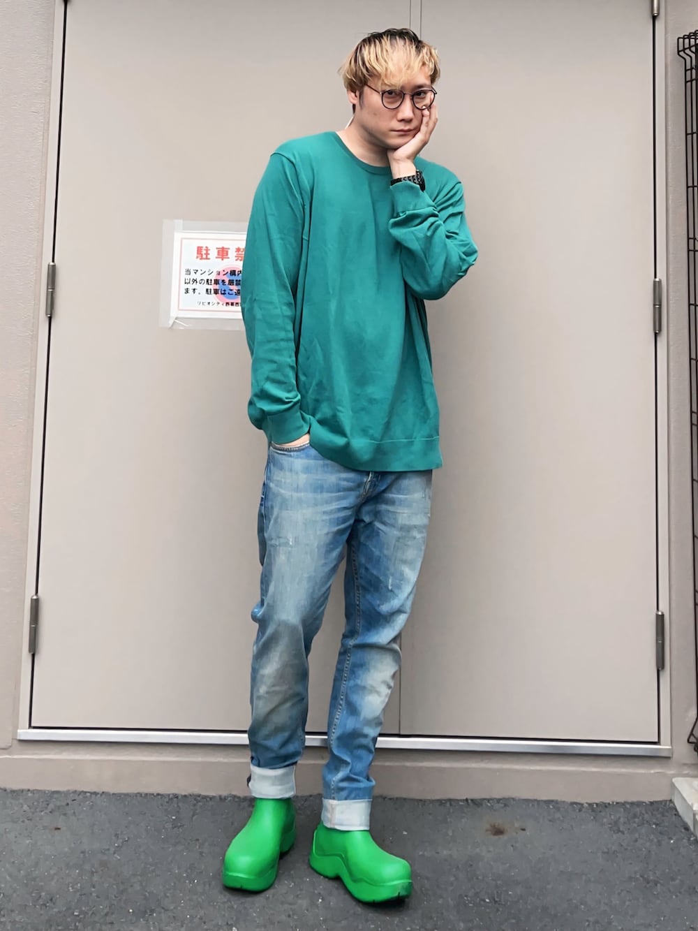 グリーン系のニット/セーター、ブルー系のデニムパンツ、グリーン系のレインシューズを着用したメンズの秋コーディネートの2枚目の写真