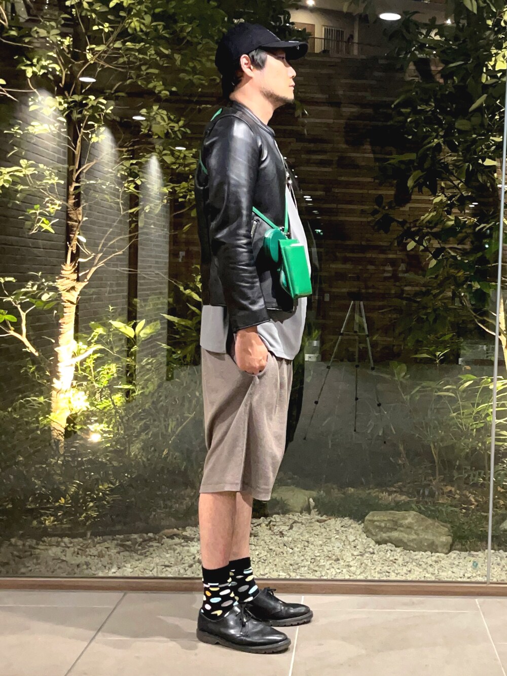 ブラック系のライダースジャケット、グリーン系のショルダーバッグ、ブラック系のその他シューズを着用したメンズの夏コーディネートの3枚目の写真