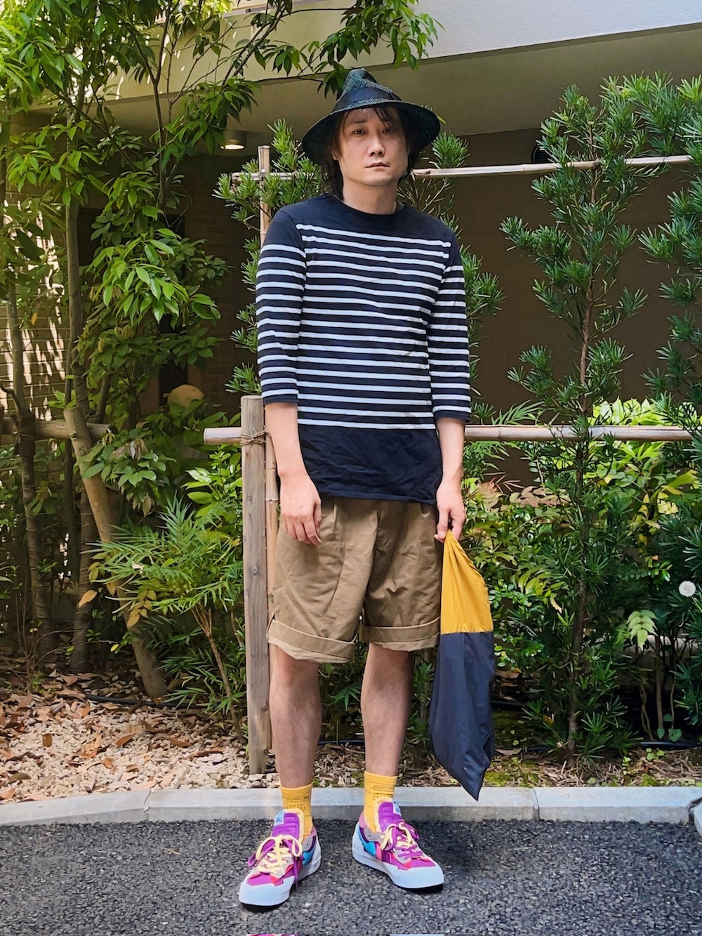 ブラック系のTシャツ/カットソー、ベージュ系のパンツ、その他のトートバッグを着用したメンズの春コーディネートの3枚目の写真