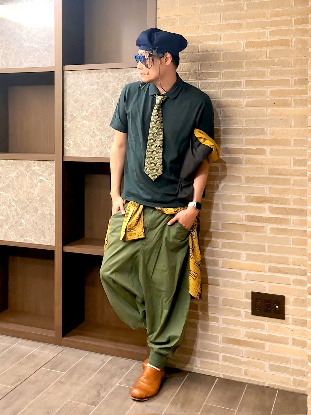 グリーン系のポロシャツ、グリーン系のその他パンツ、その他のトートバッグを着用したメンズの夏コーディネートの3枚目の写真
