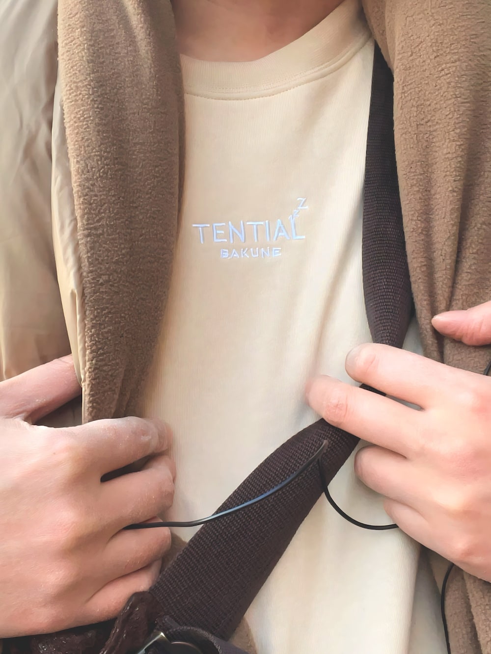 ブラウン系のボディバッグ/ウエストポーチ、ベージュ系のその他パンツ、パープル系のスニーカーを着用したメンズの冬コーディネートの2枚目の写真