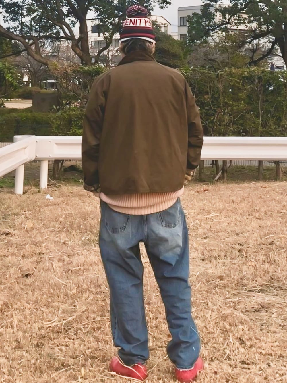 ホワイト系のニット/セーター、ピンク系のカーディガン/ボレロ、グリーン系のブルゾンを着用したメンズの冬コーディネートの2枚目の写真