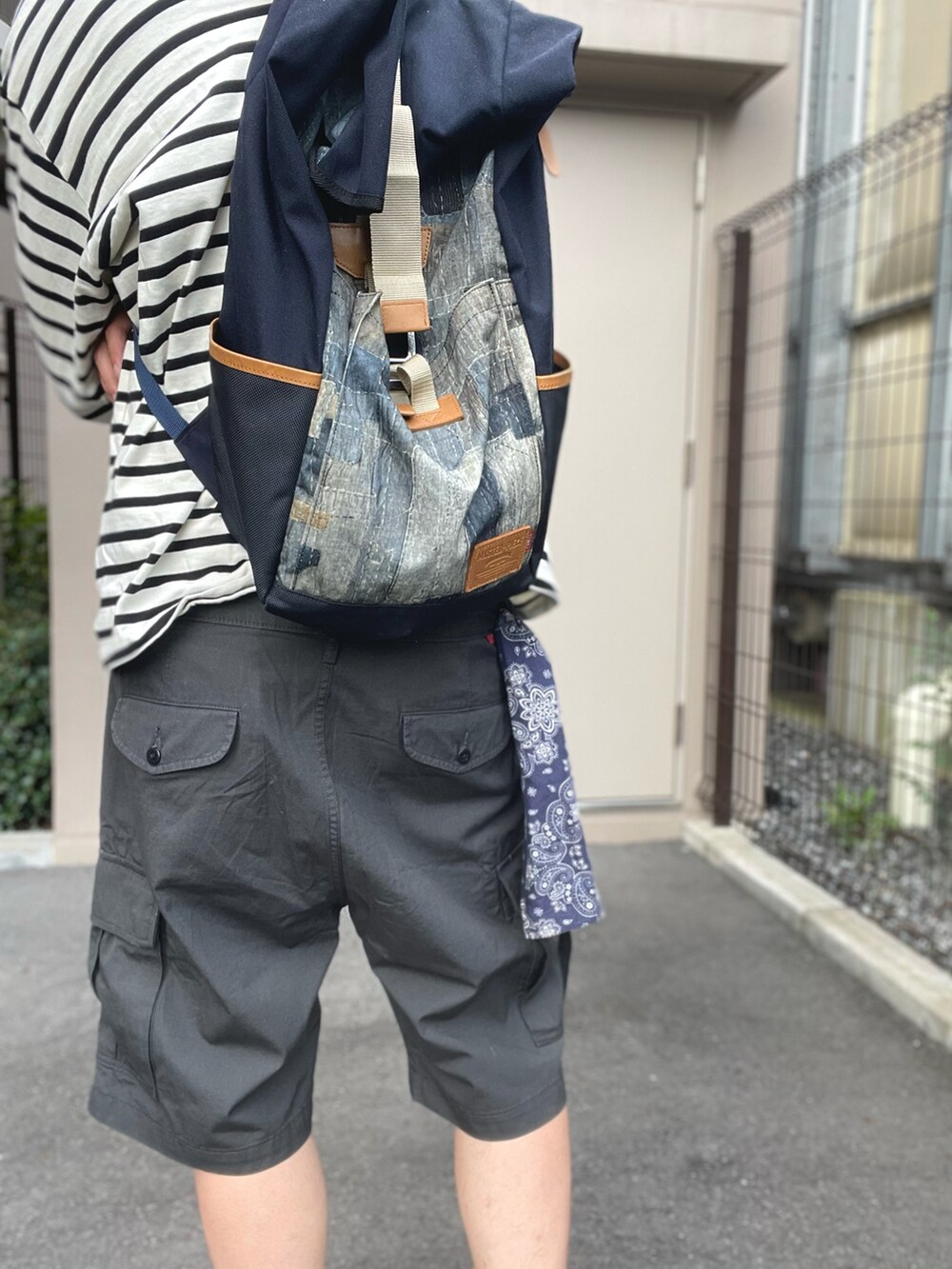 ホワイト系のTシャツ/カットソー、ブルー系のバックパック/リュック、ブラック系のカーゴパンツを着用したメンズの夏コーディネートの5枚目の写真