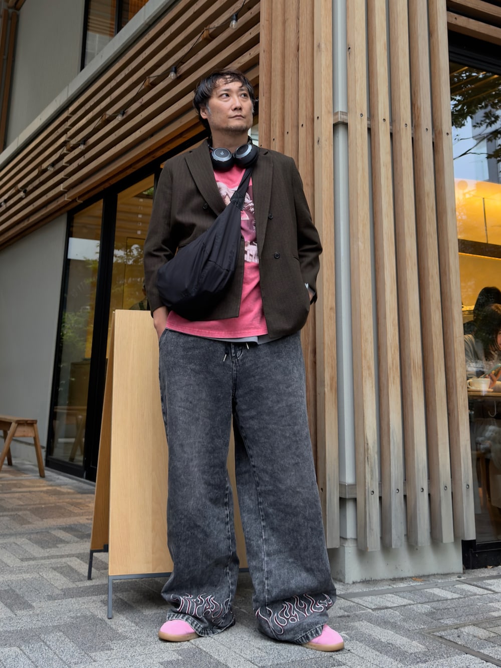レッド系のTシャツ/カットソー、ブラック系のデニムパンツ、ブラック系のショルダーバッグを着用したメンズの秋コーディネートの3枚目の写真