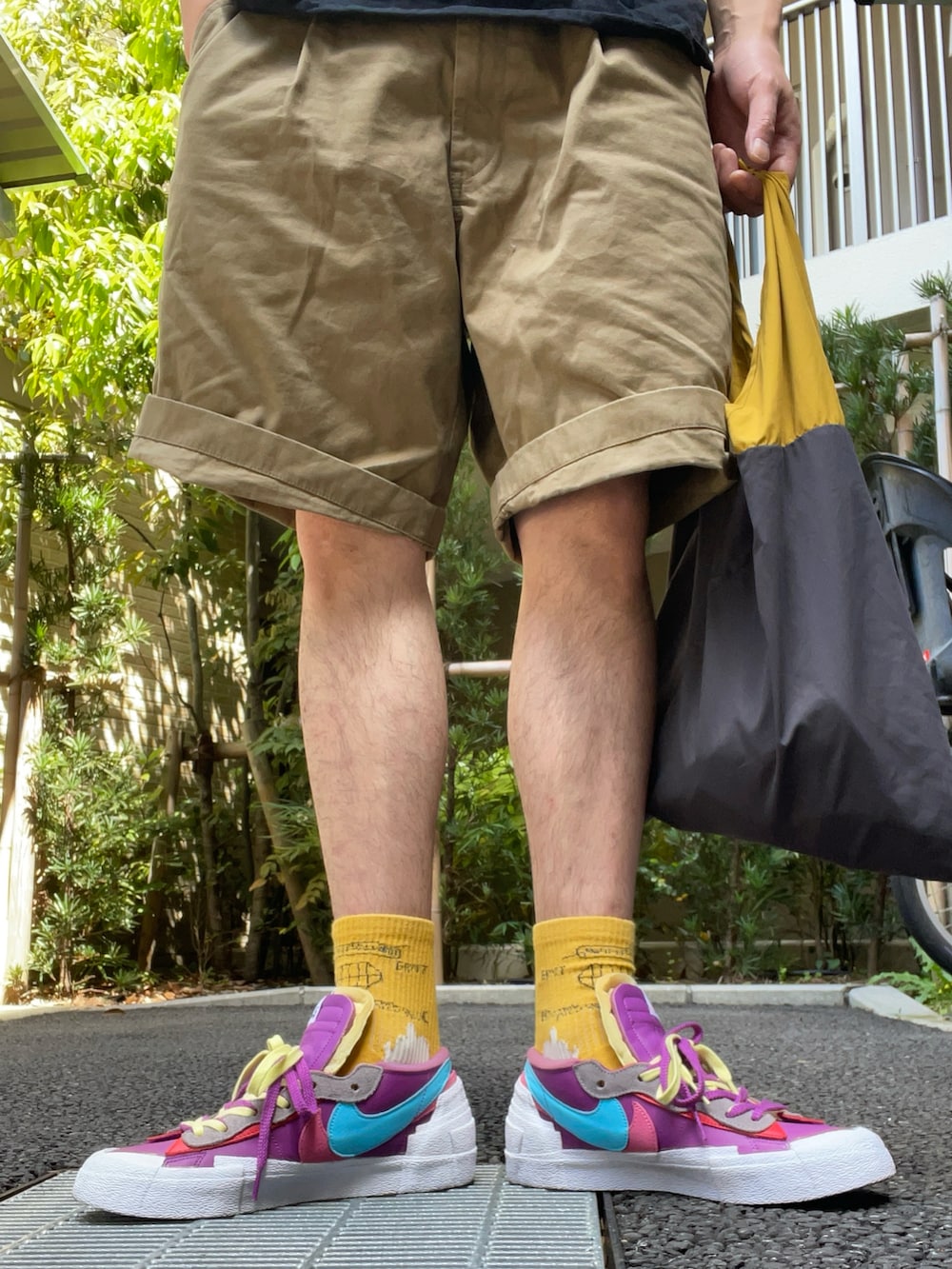 ブラック系のTシャツ/カットソー、ベージュ系のパンツ、その他のトートバッグを着用したメンズの春コーディネートの4枚目の写真