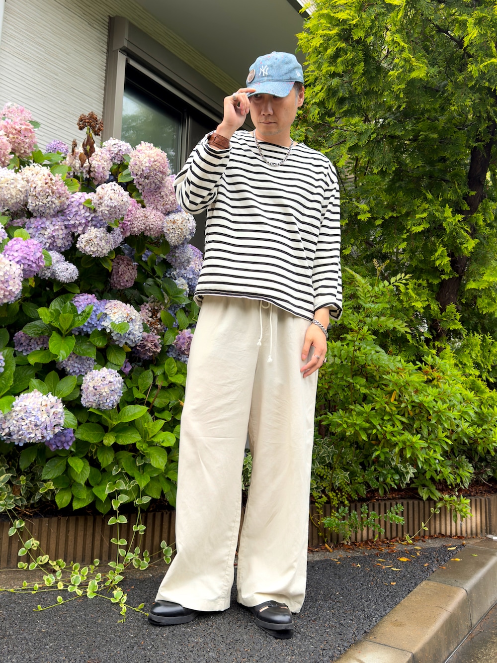 ホワイト系のTシャツ/カットソー、ブラック系のドレスシューズ、ホワイト系のパンツを着用したメンズの夏コーディネートの3枚目の写真