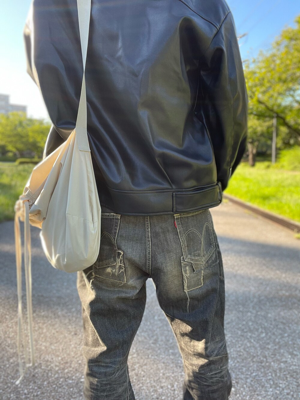 ブルー系のTシャツ/カットソー、ブラック系のライダースジャケット、ブラック系のデニムパンツを着用したメンズの秋コーディネートの3枚目の写真