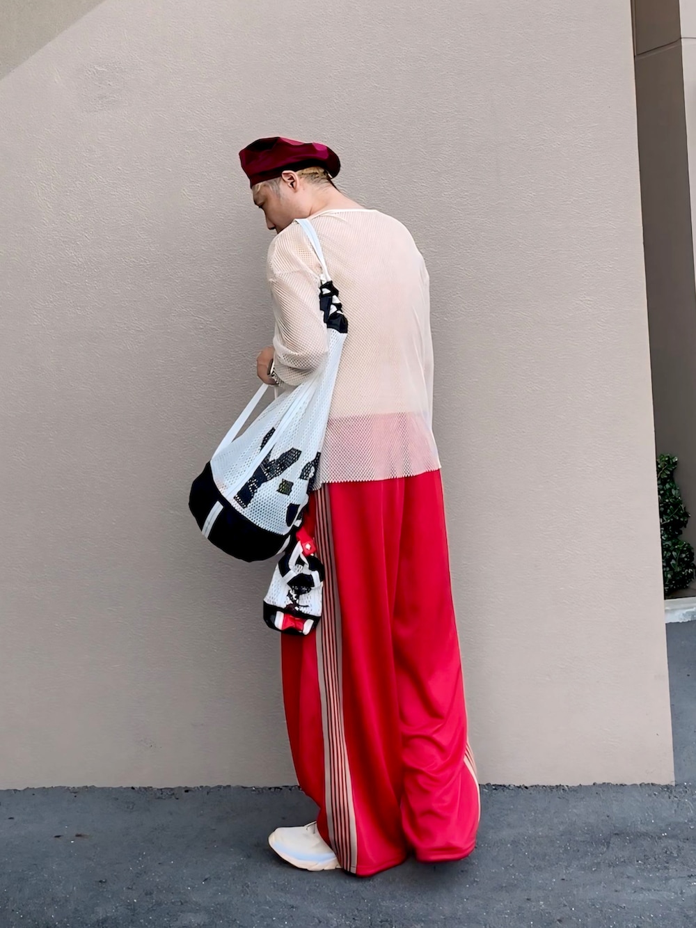 ベージュ系のTシャツ/カットソー、ブラック系のトートバッグ、レッド系のその他パンツを着用したメンズの夏コーディネートの3枚目の写真