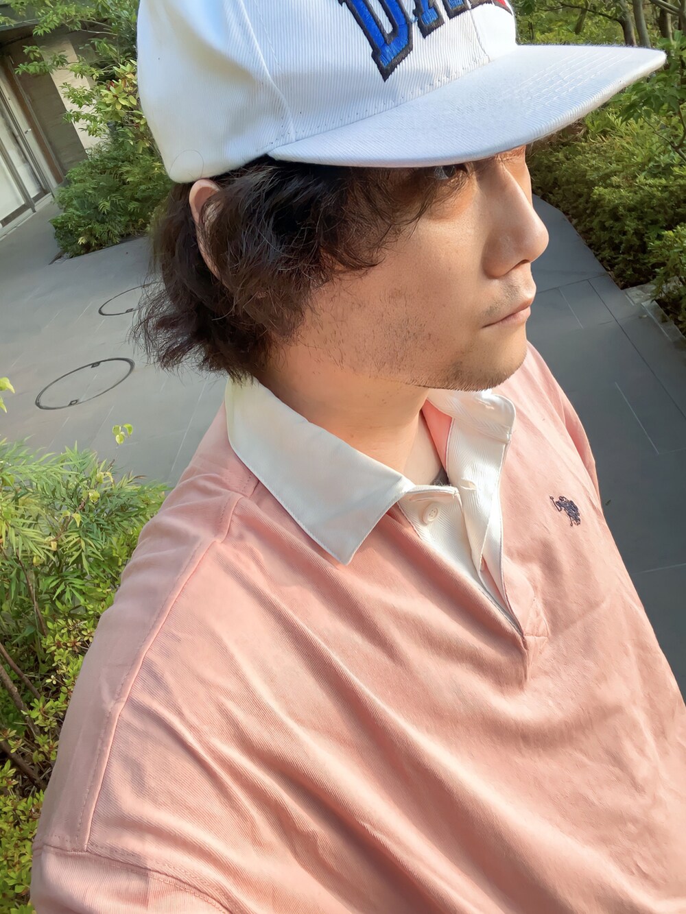 ピンク系のTシャツ/カットソー、ベージュ系のパンツ、ホワイト系のスニーカーを着用したメンズの夏コーディネートの2枚目の写真