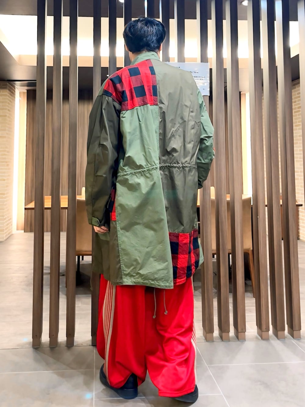 レッド系のその他パンツ、グリーン系のモッズコート、ブラック系のTシャツ/カットソーを着用したメンズの秋コーディネートの2枚目の写真