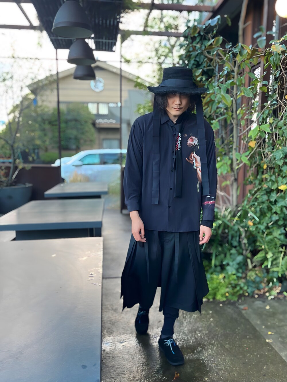 ブラック系のパンツ、ブラック系のモカシン/デッキシューズ、ブルー系のシューズアクセサリーを着用したメンズの冬コーディネートの2枚目の写真