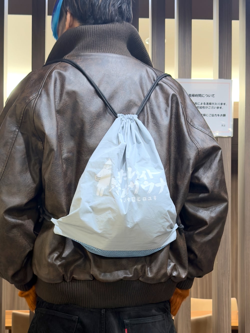 オレンジ系のニット/セーター、ブラウン系のブルゾン、ブラウン系のドレスシューズを着用したメンズの冬コーディネートの3枚目の写真