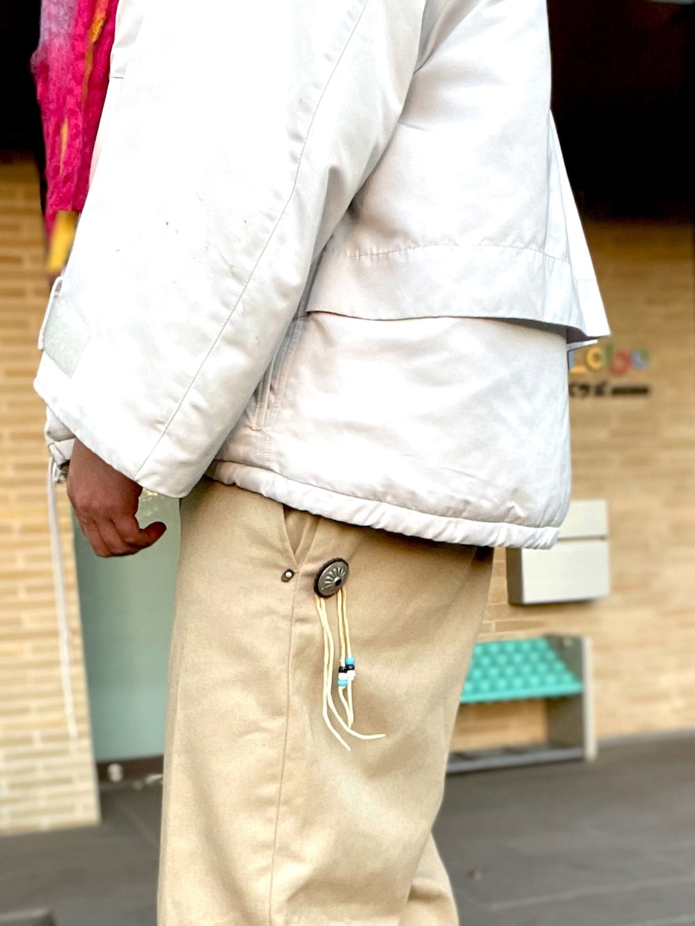 ホワイト系のダウンジャケット/コート、ベージュ系のチノパンツ、ホワイト系のドレスシューズを着用したメンズの冬コーディネートの4枚目の写真