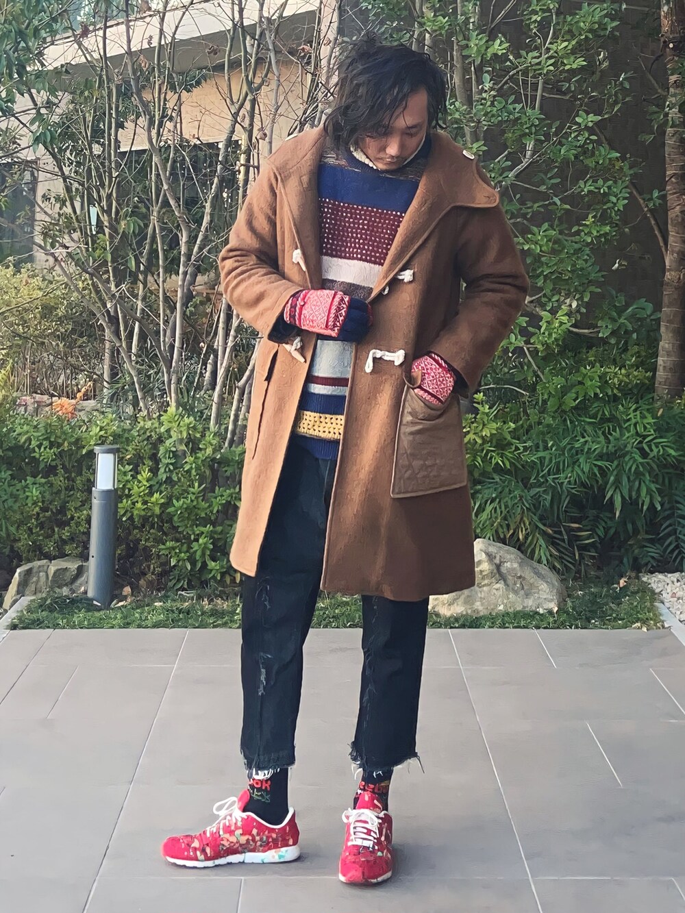 グリーン系のダッフルコート、その他のニット/セーター、ブラック系のデニムパンツを着用したメンズの春コーディネートの3枚目の写真