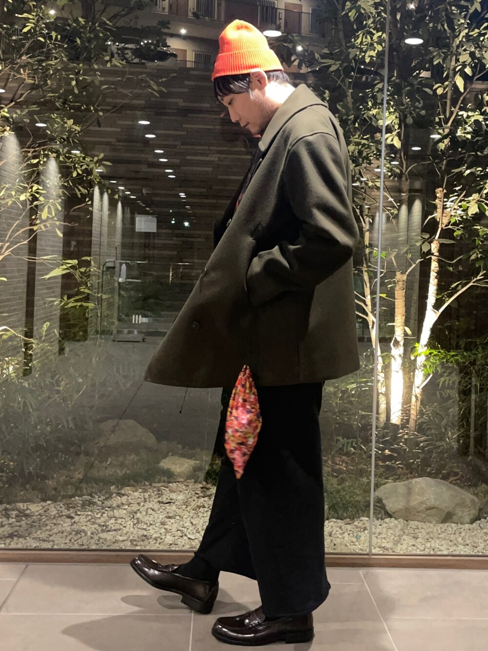 グリーン系のピーコート、ブラック系のニット/セーター、ブラック系のその他パンツを着用したメンズの冬コーディネートの2枚目の写真