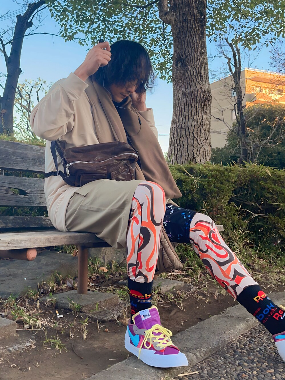 ブラウン系のボディバッグ/ウエストポーチ、ベージュ系のその他パンツ、パープル系のスニーカーを着用したメンズの冬コーディネートの5枚目の写真