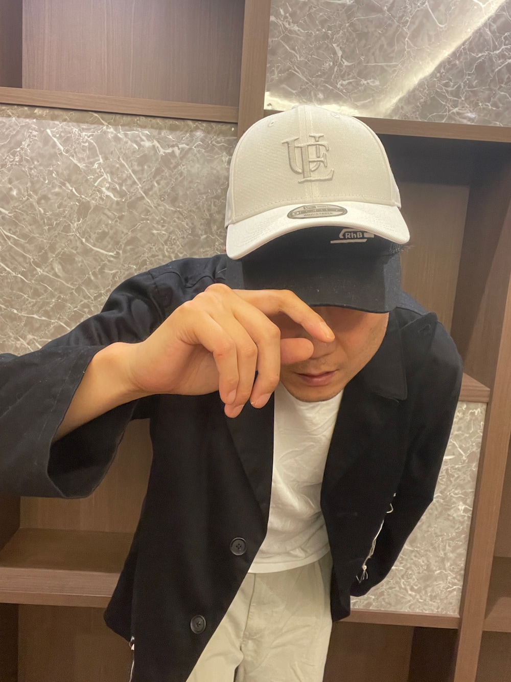 ホワイト系のTシャツ/カットソー、ブラック系のジャケット/アウター、ベージュ系のチノパンツを着用したメンズの秋コーディネートの4枚目の写真